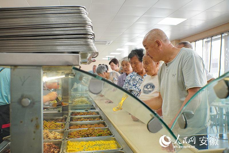 恒通社區(qū)老年食堂內，老人們正在排隊打菜。人民網(wǎng) 陳若天攝