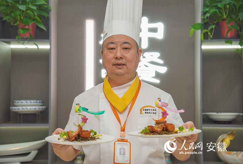 1汪幸生展示經(jīng)典徽菜毛峰熏脆皮鱸魚。人民網(wǎng) 陳若天攝
