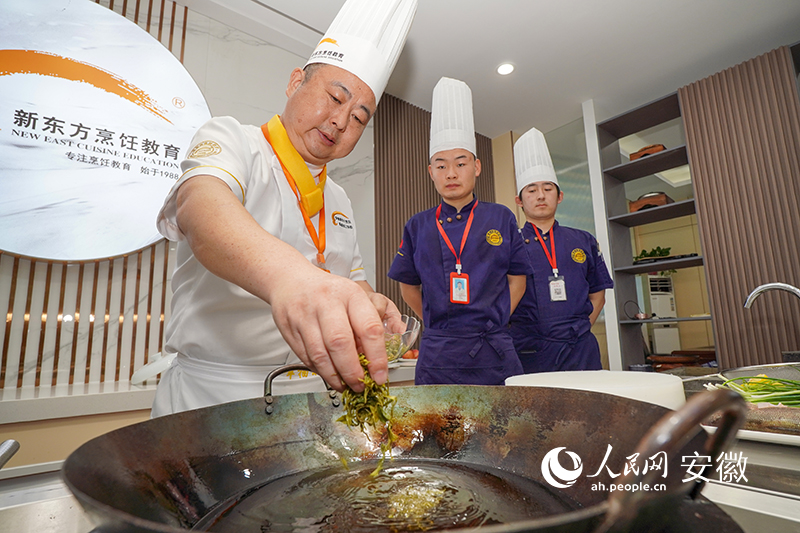3制作毛峰熏脆皮鱸魚的步驟之一，將毛峰茶葉下鍋。人民網(wǎng) 陳若天攝