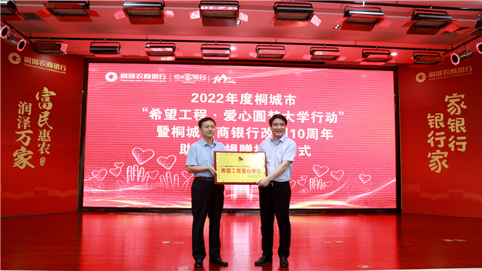 洪長(zhǎng)久向桐城農(nóng)商銀行授“2022年度希望工程愛(ài)心單位”牌匾