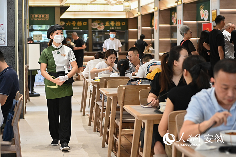 在阜陽(yáng)名小吃旗艦店大廳，前來(lái)品嘗美食的顧客絡(luò)繹不絕。人民網(wǎng)記者 苗子健攝 