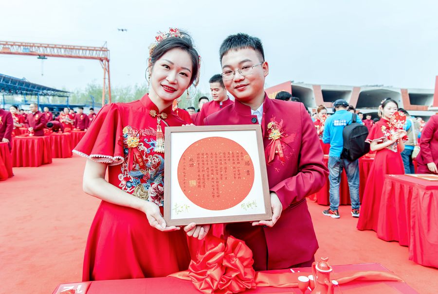  婚禮現(xiàn)場新人展示剛剛寫上姓名的婚書。中鐵四局供圖