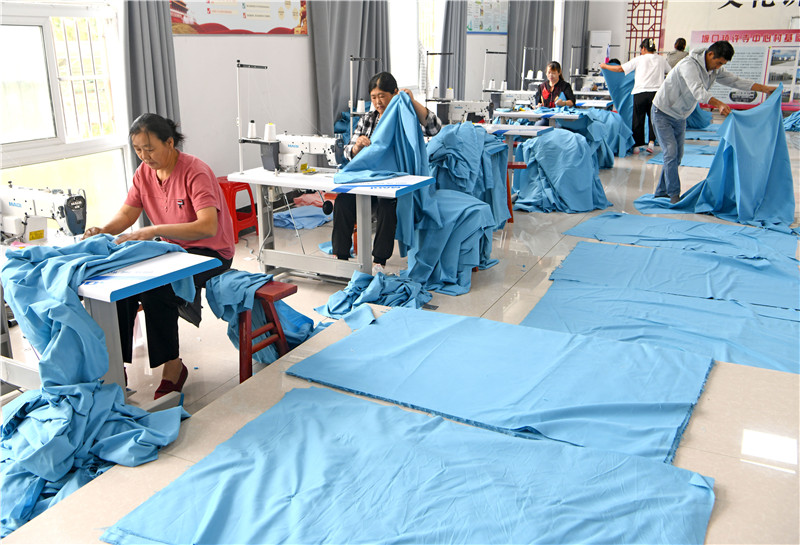 村民學(xué)習(xí)縫紉技術(shù)，加工被套出口海外。陳彬攝