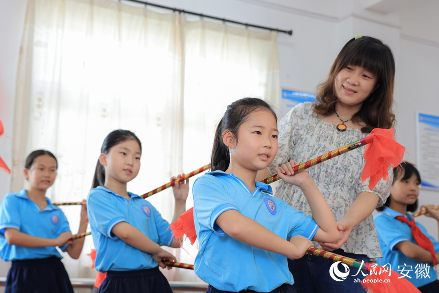 一位老師正在給學(xué)生指導(dǎo)蓮湘舞的動(dòng)作。人民網(wǎng) 王曉飛攝