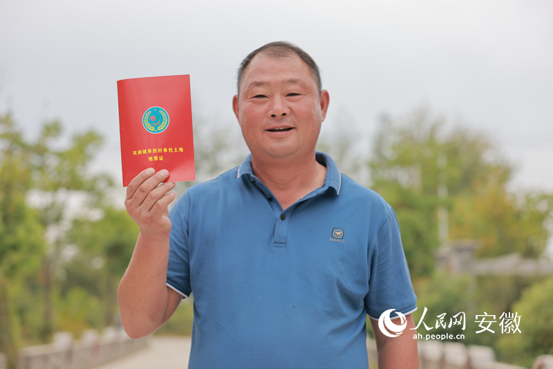 一位種糧大戶興奮地展示自己簽訂的承包土地地票證。人民網(wǎng) 王曉飛攝