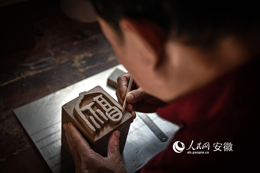 老師傅在陶泥上雕刻“?！弊帧Ｈ嗣窬W記者 苗子健攝