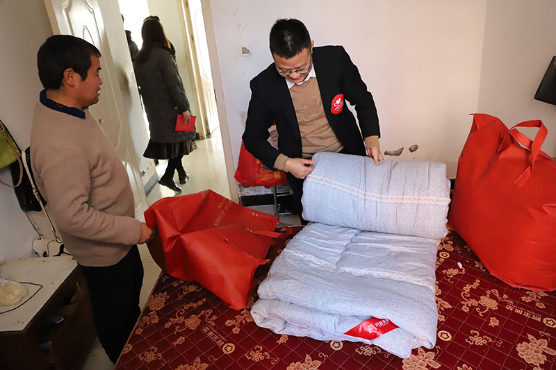 賈汝濤幫李衛(wèi)東將新買的棉被鋪好。丁明駿攝