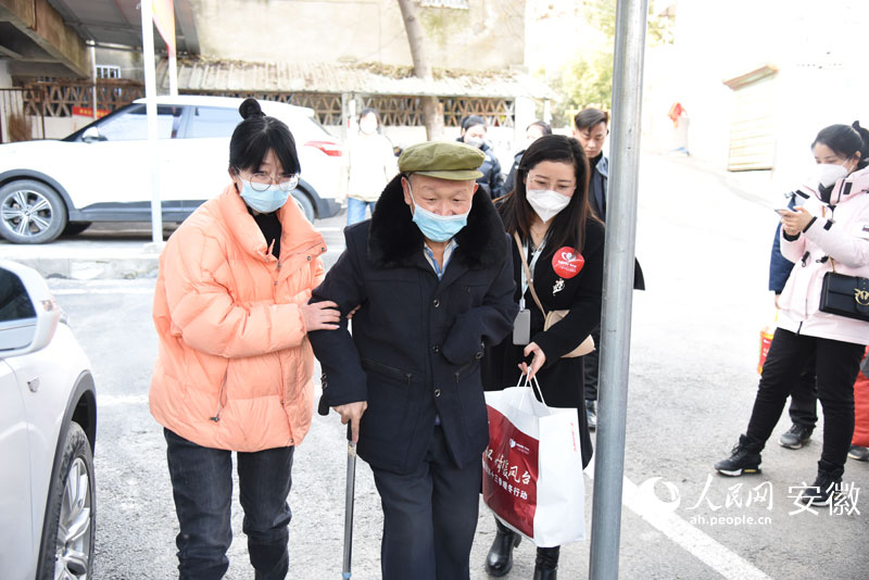 方燁和志愿者一起攙扶著丁龍回家。人民網(wǎng) 李希蒙攝