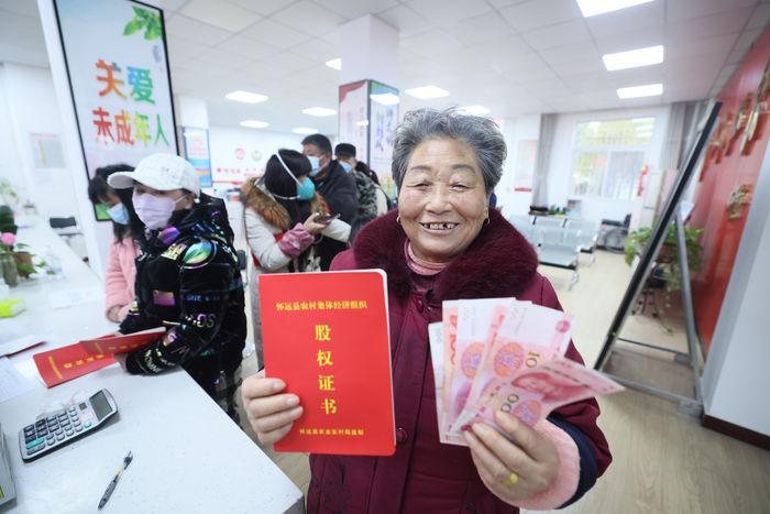 新懷社區(qū)居民展示股權(quán)證書和領(lǐng)到的分紅。懷遠(yuǎn)縣委宣傳部供圖