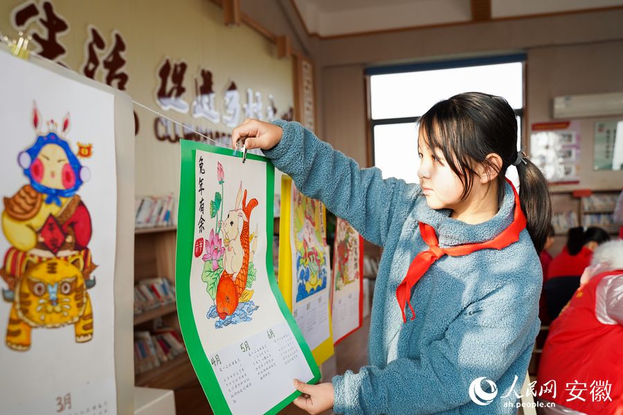 留守兒童展示繪畫作品。人民網(wǎng) 王銳攝