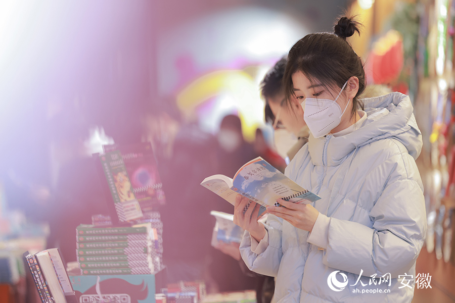 一位女孩正在翻閱圖書(shū)。人民網(wǎng) 王曉飛攝