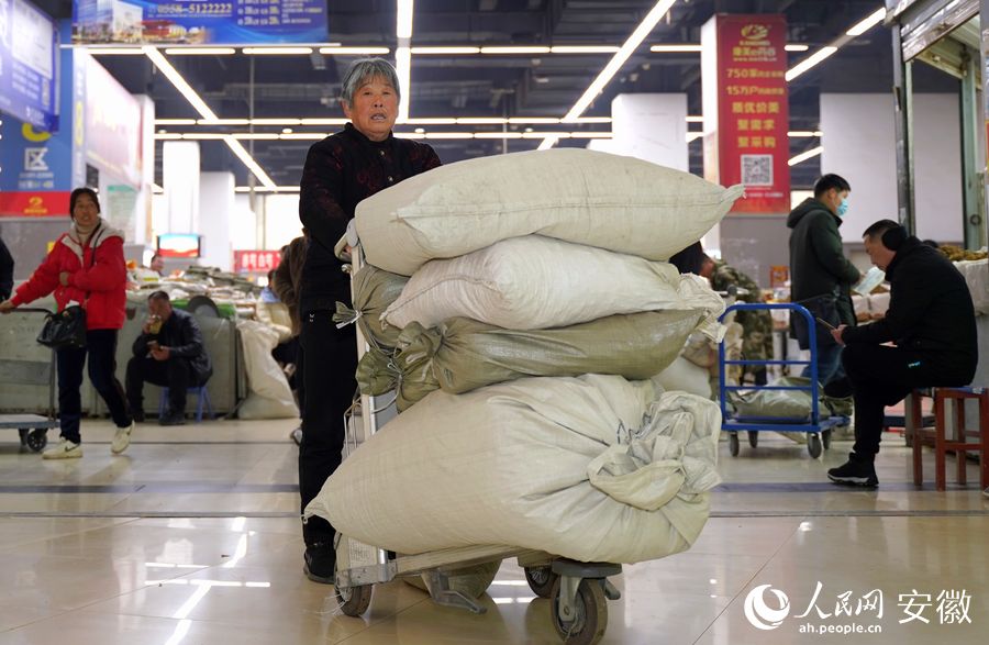 到亳州中藥材市場采購的顧客推著車滿載而歸。人民網(wǎng) 王銳攝