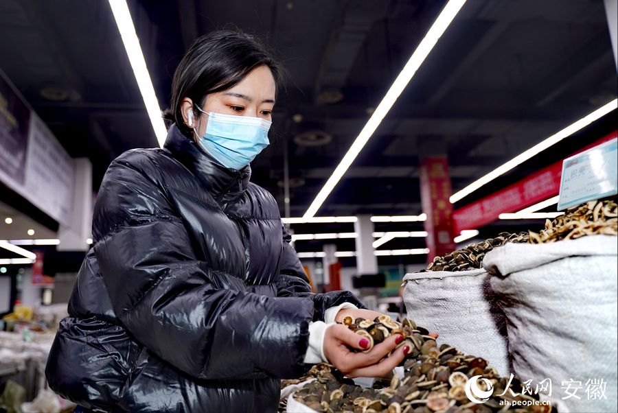 顧客正在仔細觀察中藥材的品質(zhì)。人民網(wǎng) 王銳攝