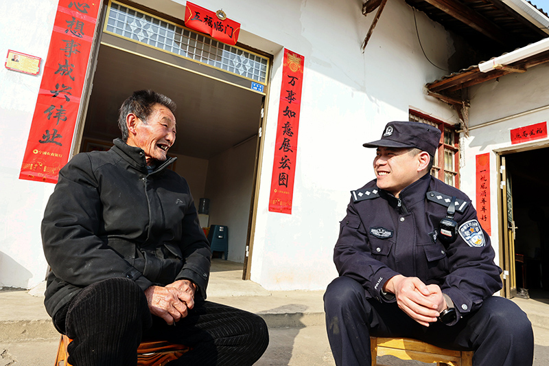 梅林派出所民警與朱忠貴老人交談。高鵬攝