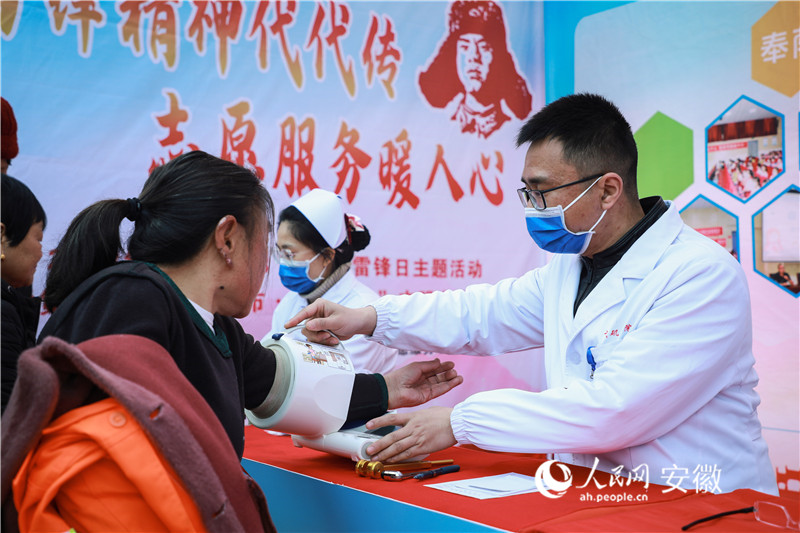 b“健康無(wú)為”志愿服務(wù)隊(duì)的志愿者們正在分給當(dāng)?shù)鼐用襁M(jìn)行體檢。人民網(wǎng) 陶濤攝