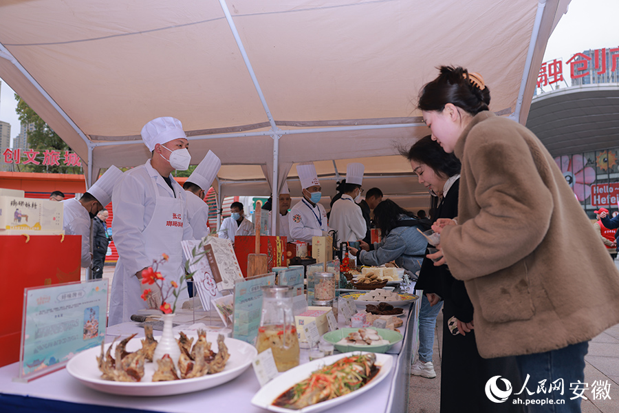 游客在滁州展臺前品嘗美食。人民網(wǎng) 王曉飛攝