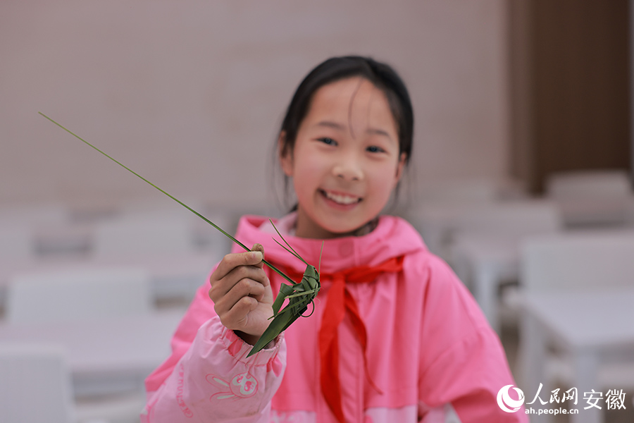 一位女孩展示自己編的蚱蜢。人民網(wǎng) 王曉飛攝
