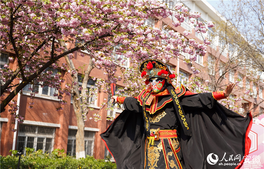 櫻花樹下，學生正在表演川劇變臉。人民網(wǎng) 王銳攝