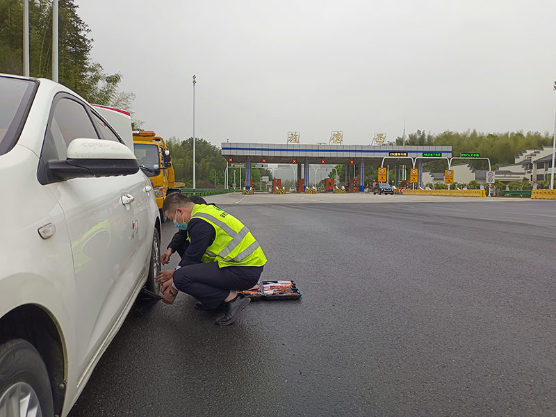 旌德西站員工盧大順在道口幫助司乘更輪車輛胎換。皖通高速供圖