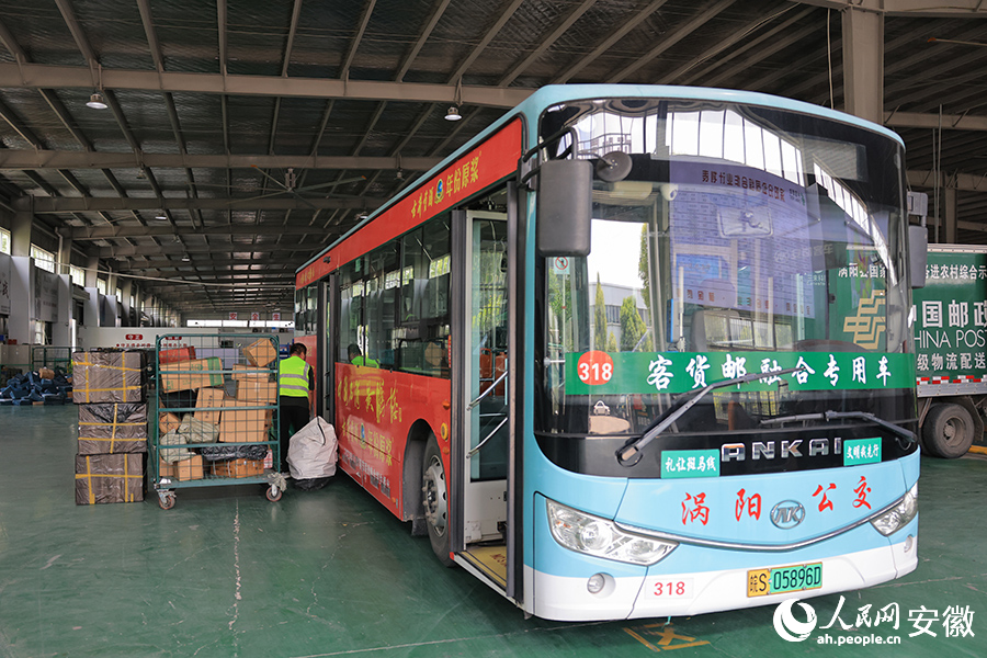 工作人員正在將快件搬到客貨郵融合專用公交車上。人民網(wǎng)記者 王曉飛攝