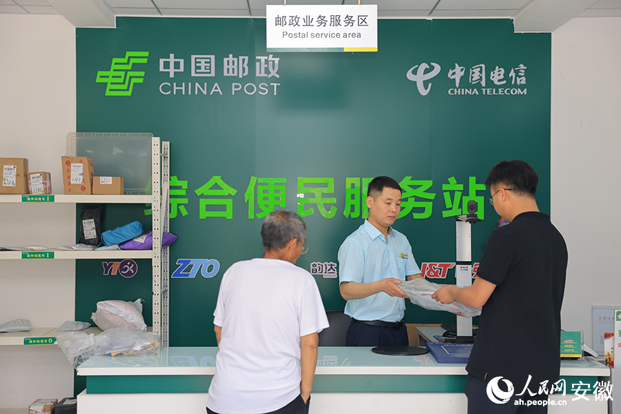郵政綜合便民服務(wù)站內(nèi)，百姓前來收取快件。人民網(wǎng)記者 王曉飛攝