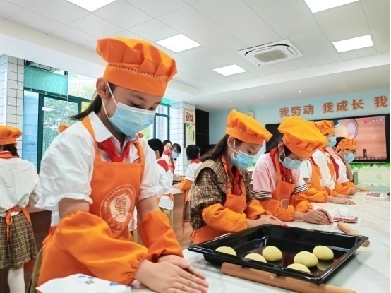 六安市皋城小學(xué)烹飪課上，潘雨樂(lè)正在制作面包。人民網(wǎng)記者王銳 攝