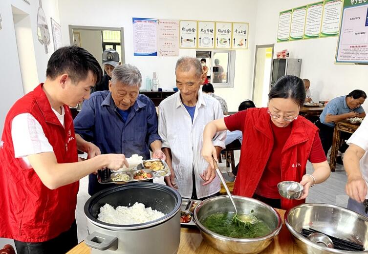 志愿者為老年人打飯。余申發(fā)供圖
