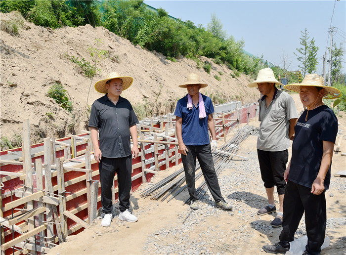 汛期將要到來，傅新舉督促楊廟村果園排水通道建設(shè)工程，為果園及時(shí)排水打下基礎(chǔ)。李艷龍攝