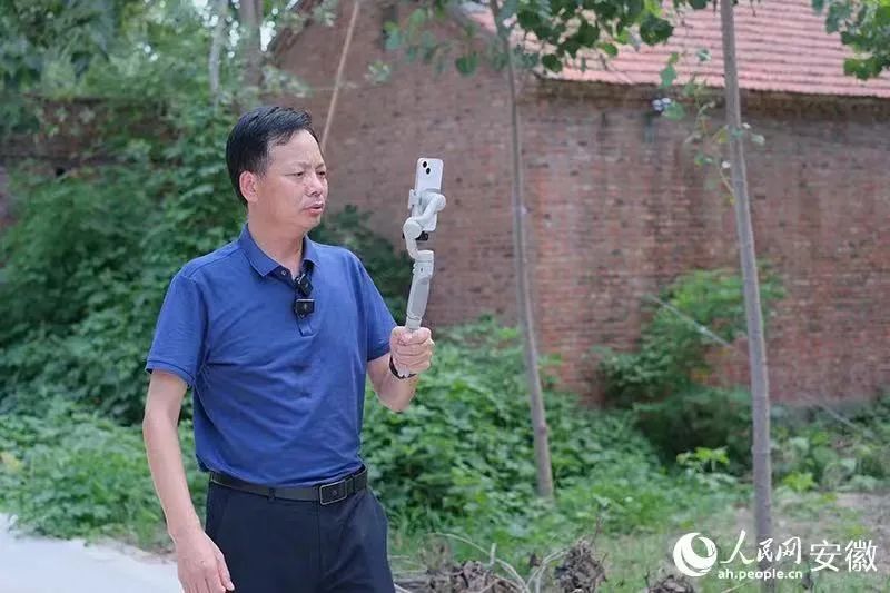手持穩(wěn)定儀的孫善豹，隔著手機(jī)屏和網(wǎng)友在線交流。人民網(wǎng)記者 汪瑞華攝