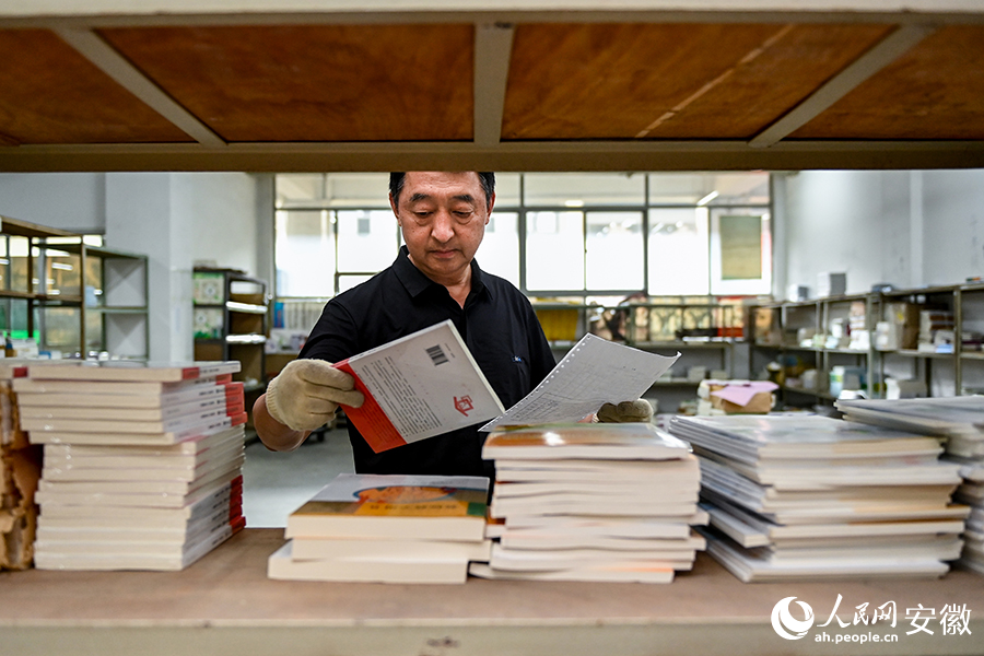 工作人員對照目錄配發(fā)教輔書籍。人民網(wǎng)記者 苗子健攝