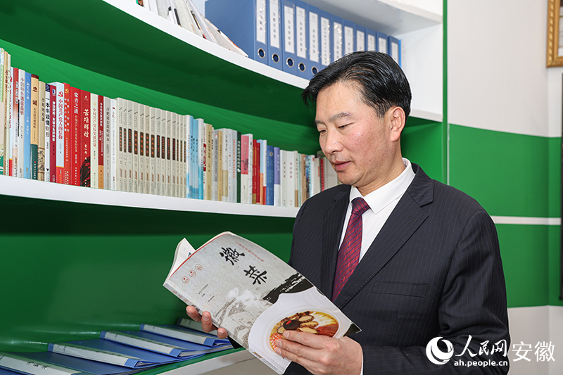 胡建東翻閱徽菜書(shū)籍。人民網(wǎng)記者 張俊攝