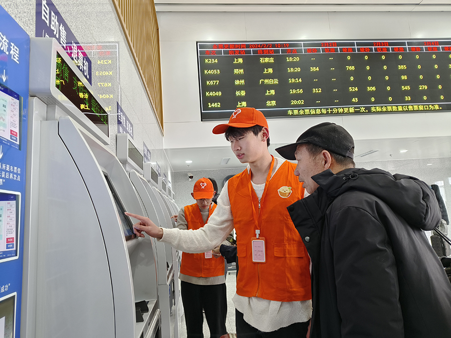 車站青年志愿者熱情幫助老年旅客解決問題。宿州火車站供圖