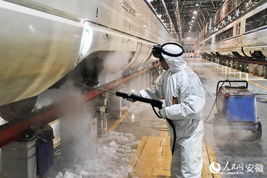地勤機械師清除覆冰，保障列車安全。人民網(wǎng)記者 周坤攝