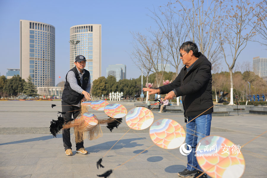 余又勝在進(jìn)行放飛龍串風(fēng)箏前的準(zhǔn)備工作。人民網(wǎng)記者 王曉飛攝