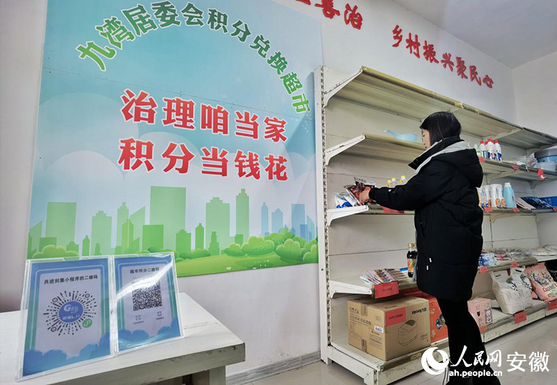 九灣村居委會(huì)工作人員整理積分超市的“獎(jiǎng)品”。人民網(wǎng)記者 陶濤攝