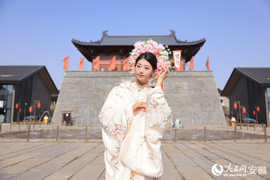 一位頭戴簪花的女孩在撮街留影。人民網(wǎng)記者 王曉飛攝