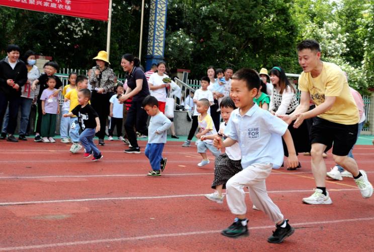 家長(zhǎng)帶孩子在清流小學(xué)操場(chǎng)運(yùn)動(dòng)。李曉村 攝