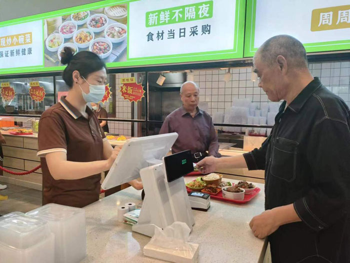 老年居民在銅陵某社區(qū)食堂使用助餐服務(wù)系統(tǒng)就餐（取餐）。工行安徽省分行供圖