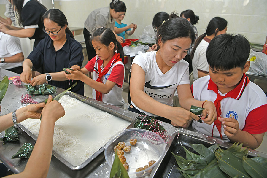 2024年6月6日，安徽省淮南市鳳臺縣第四實驗小學學生在老師的指導下學習包粽子。