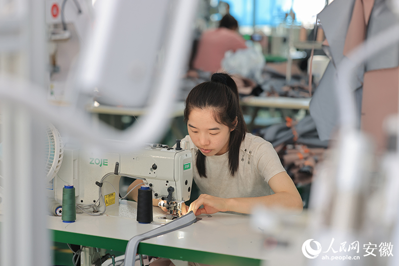 生產(chǎn)車間內(nèi)，一名女工正在忙碌。人民網(wǎng)記者 王曉飛攝