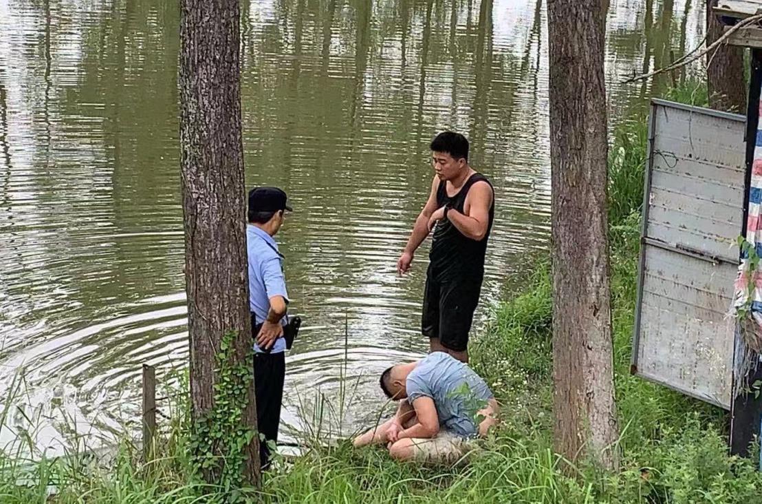 朱仁君（圖右）在岸邊民警的幫助下，成功將落水男孩營救上岸。周玉軍攝