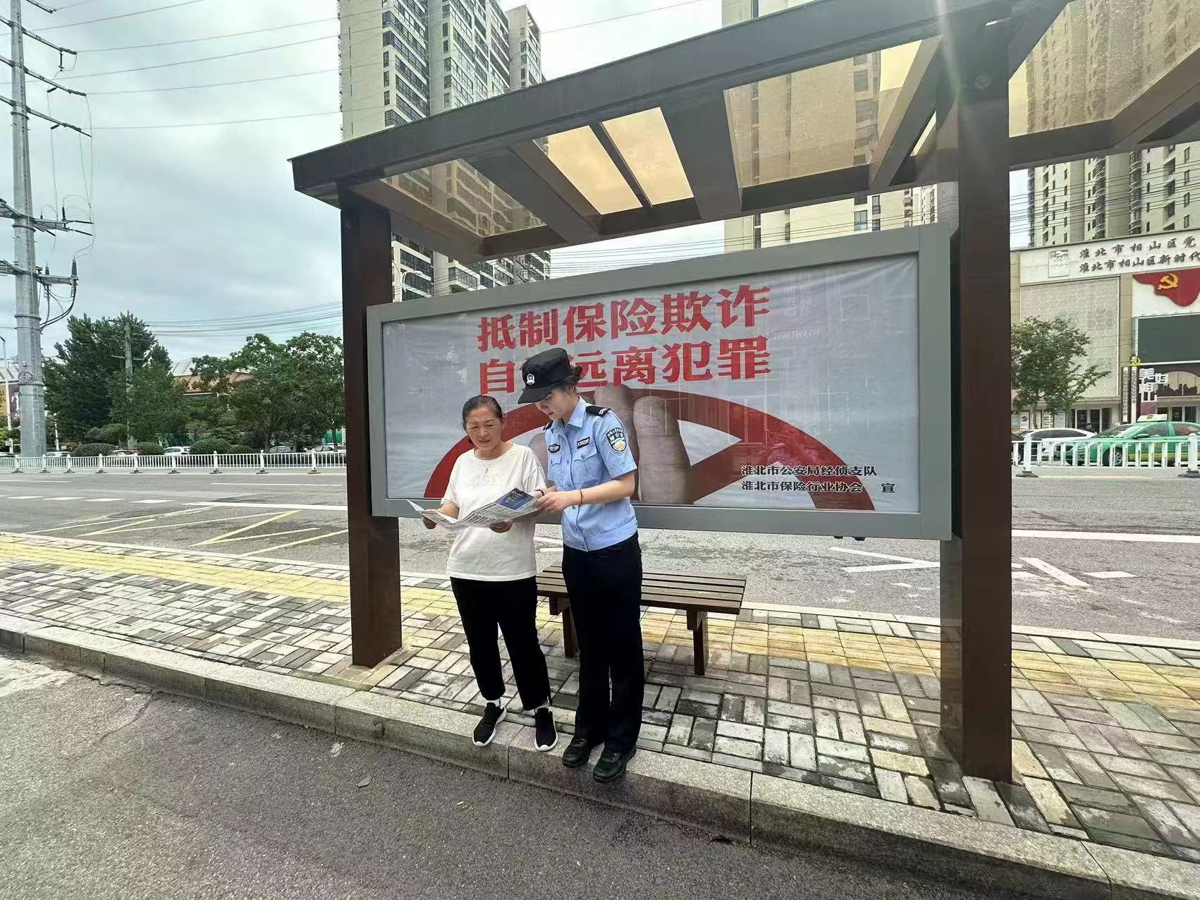 保險(xiǎn)反欺詐宣傳海報(bào)安裝同時(shí)，民警向等待乘車的市民宣傳保險(xiǎn)反欺詐知識(shí)