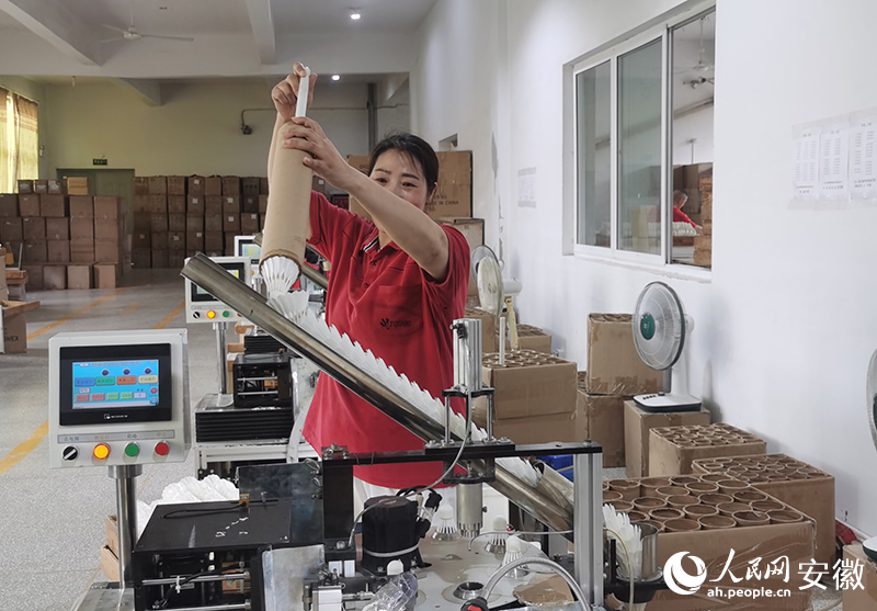 操作工將羽毛球裝進(jìn)捆線機(jī)。人民網(wǎng) 胡雨松攝