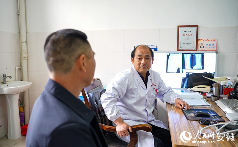 方建武正在為門診患者解決問題。人民網(wǎng)記者 王銳攝