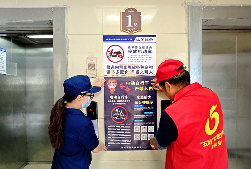 消防志愿者張貼消防宣傳海報。資料圖片