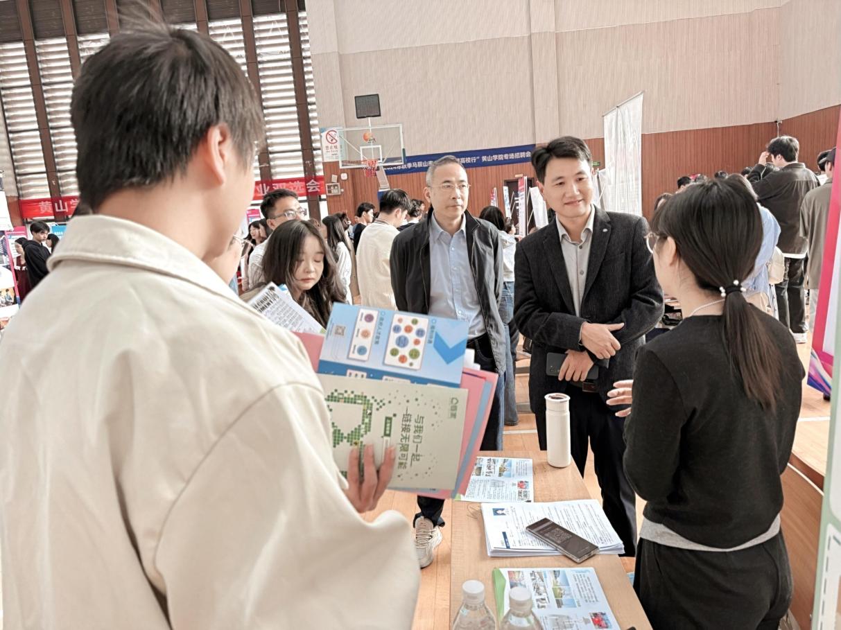 校地雙方代表在企業(yè)攤位前熱切交流