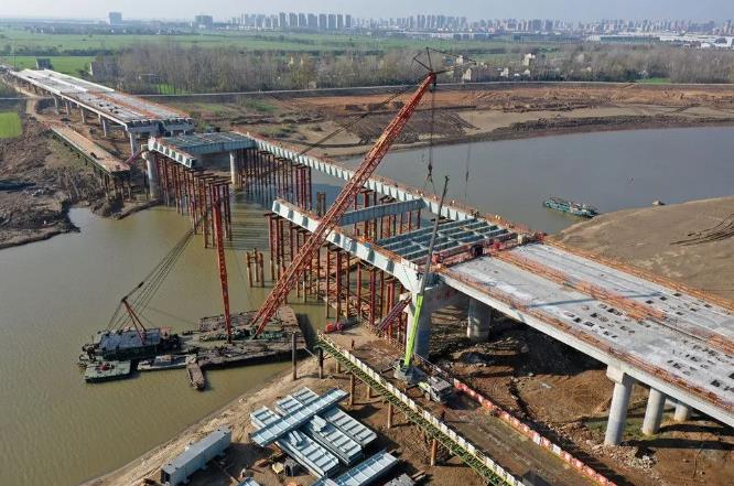 11月23日，工人正在蒙城縣境內亳蒙高速二期建設工地進行梁板吊裝作業(yè)。