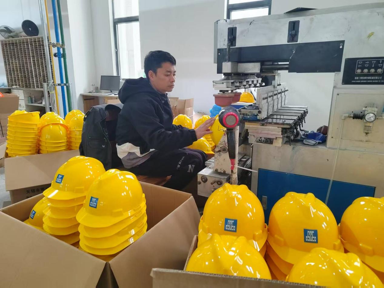 安徽賽邦安全設(shè)備有限公車車間內(nèi)，工人正在安全帽噴涂標(biāo)識(shí)。曹慶攝