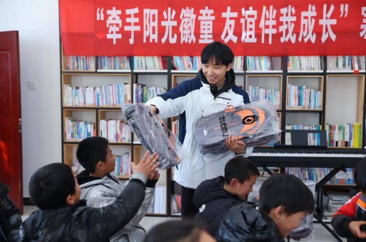 活動(dòng)現(xiàn)場(chǎng)，江淮汽車的志愿者為孩子們分發(fā)捐贈(zèng)的禮物。