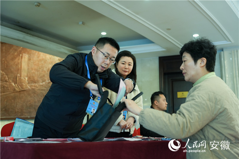 工作人員為安徽省政協(xié)委員發(fā)放參會(huì)材料。人民網(wǎng)記者 王銳攝